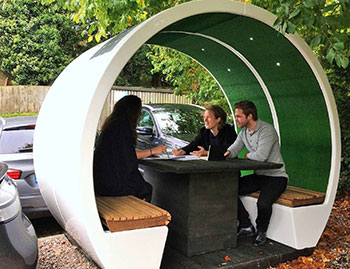 Exterior pod in office car park with table and people having a meeting